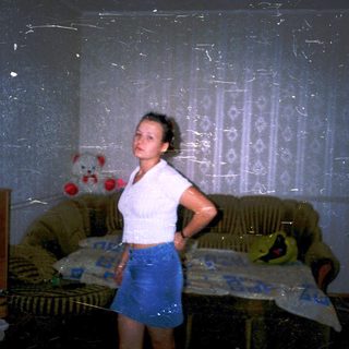 A person standing in a damaged, dimly lit room.