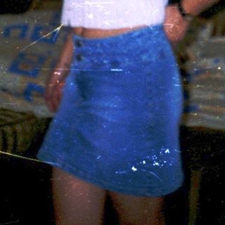 A person standing in a damaged, dimly lit room.
