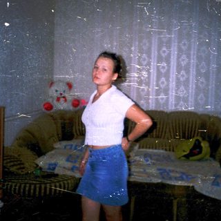 A person standing in a damaged, dimly lit room.