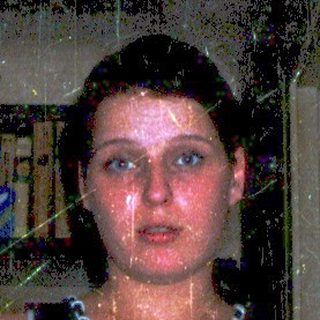 Woman standing in shower with man looking up.