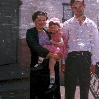 Family portrait with three generations outdoors.