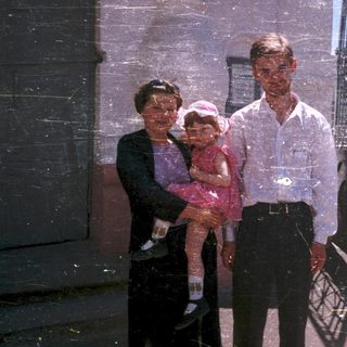 Family portrait with three generations outdoors.