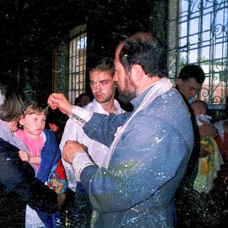 Holy water blessing ceremony with child.