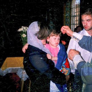 Holy water blessing ceremony with child.