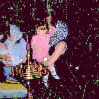 Children playing with sparklers at nighttime celebration.