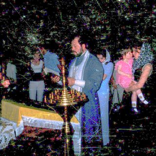 Religious ceremony with candle lighting and children present.