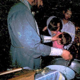 Ritual baptism with infant in church setting.