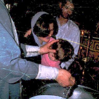 Ritual baptism with infant in church setting.