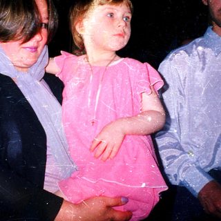 Wet children and adult at nighttime celebration.