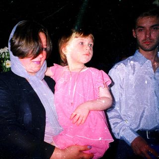 Wet children and adult at nighttime celebration.