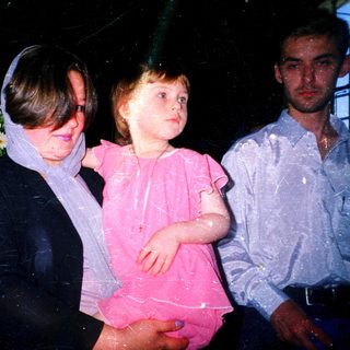 Wet children and adult at nighttime celebration.