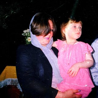 Wet children and adult at nighttime celebration.