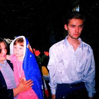Family group outdoors at nighttime event.
