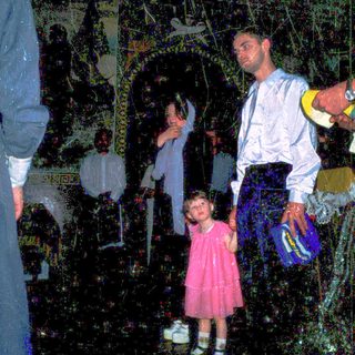 Family in dark, dimly lit indoor space with decorative lanterns.