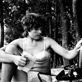 Woman cooking outdoors in natural setting.