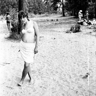 Woman walking barefoot in outdoor setting.