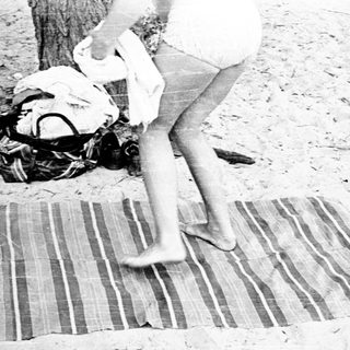 Person stepping on a mat near beach.