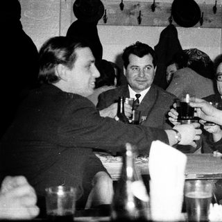 Group of people toasting at a formal indoor gathering.