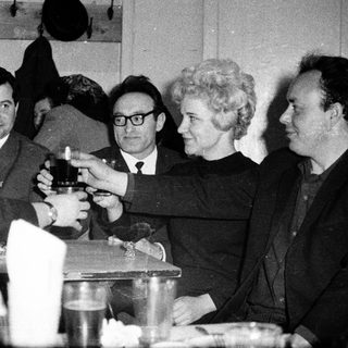 Group of people toasting at a formal indoor gathering.