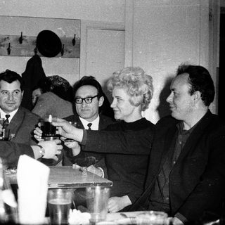 Group of people toasting at a formal indoor gathering.