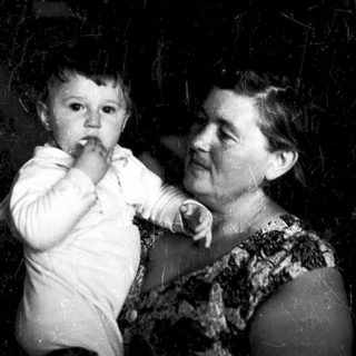 Toddler playing peekaboo with elderly woman.