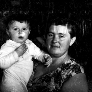 A woman holding a young child indoors.