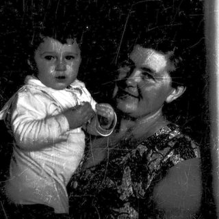 A woman holding a baby indoors.