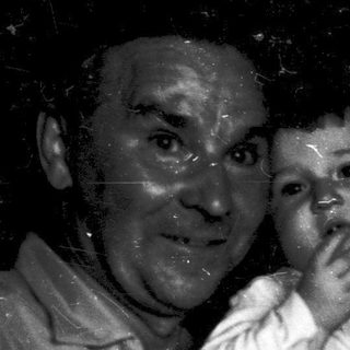 A wet, joyful family moment with grandparents holding a baby.