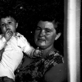 A wet, joyful family moment with grandparents holding a baby.