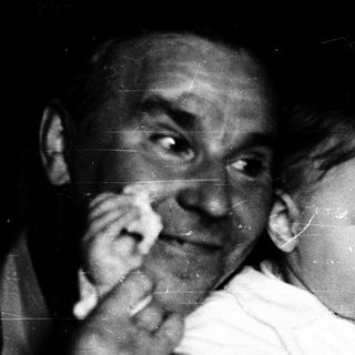 Tender moment of elderly couple holding baby indoors.