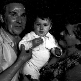 A man holding a crying baby indoors.