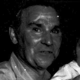 A man holding a crying baby indoors.