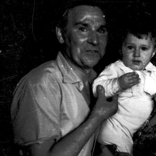 A man holding a crying baby indoors.