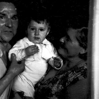 A man holding a crying baby indoors.