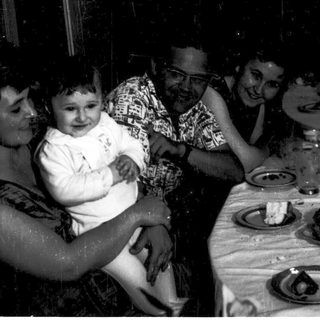 Family gathering with baby at outdoor evening meal.