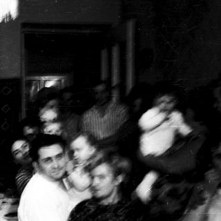 Blurred indoor group dancing at nighttime event.