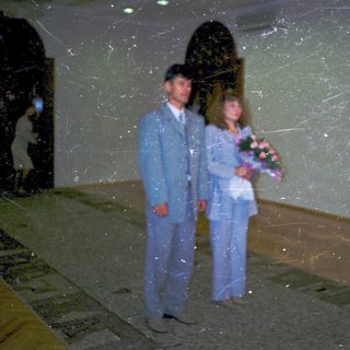 Couple in formal attire holding bouquet.