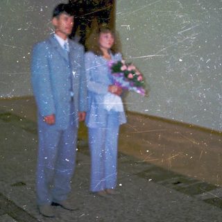 Couple in formal attire holding bouquet.