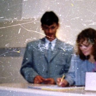 Three people signing documents at a registration desk.