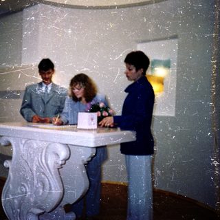 Three people signing documents at a registration desk.
