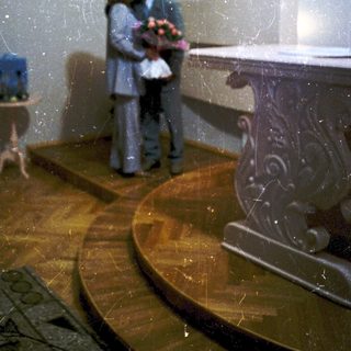 Couple embracing near baptismal font in church.