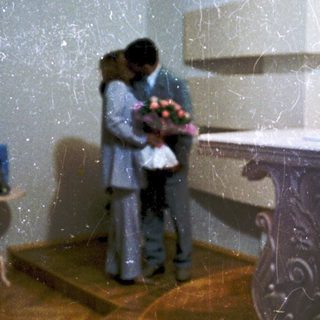 Couple embracing near baptismal font in church.