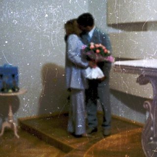 Couple embracing near baptismal font in church.