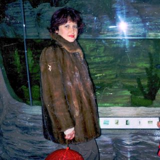 A woman and child near large indoor aquarium tank.
