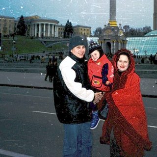 Family posing in Independence Square, Kyiv, winter.
