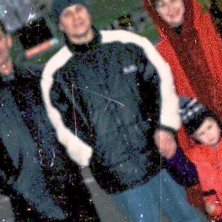 Family posing in snowy city square.