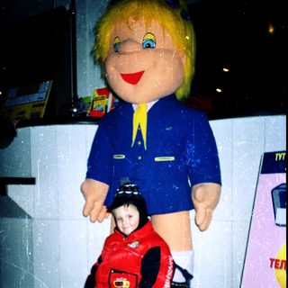Large mascot figure with child in red jacket.