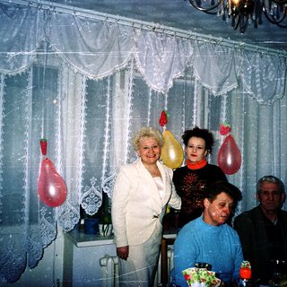 Family celebration with cake and balloons indoors.