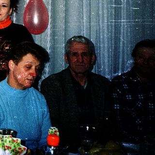 Family celebration with cake and balloons indoors.