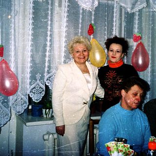 Family celebration with cake and balloons indoors.